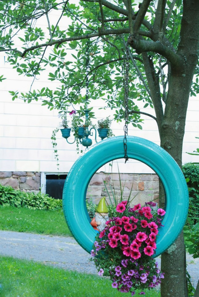 Кашпо для цветов из шины, подвешенной вертикально к дереву, - простой и эффектный способ украсить территорию дома
