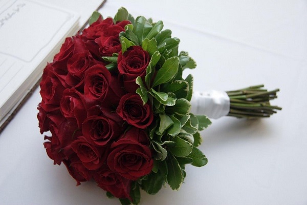Темно-красные розы сильно привлекают к себе внимание, если подобраны к белому платью