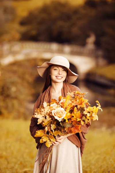Молодая женщина, прогулки в Осенний парк с букетом падения leav — стоковое фото