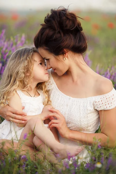 Happy mother and daughter in a field of blooming lavender — стоковое фото