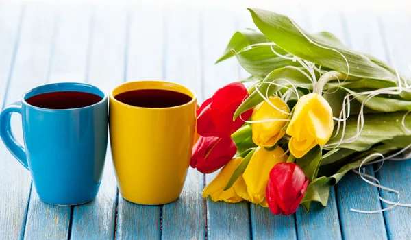 Две чашки кофе и букет из тюльпанов — стоковое фото