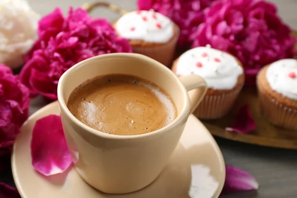 Композиция с чашкой кофе, булочки и пион цветы на фоне деревянные — стоковое фото
