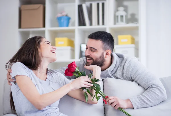 Молодой человек, давая красную розу своей подруге — стоковое фото