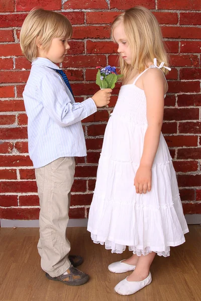 Маленький мальчик дает девушке красивый букет цветов. Любовь кон — стоковое фото