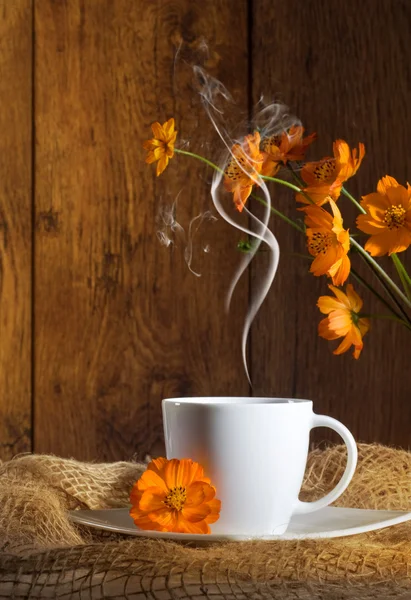 Чашка кофе с оранжевыми цветами — стоковое фото