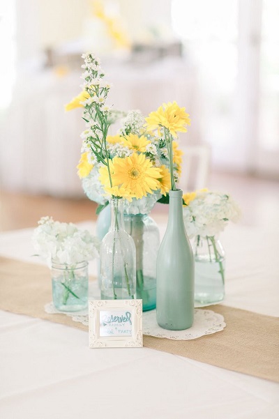 Мятные бутылки и желтые цветы в свадебном оформлении