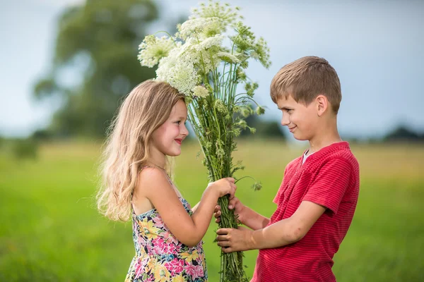Spring. Boy gives girl a bouquet of flowers . — стоковое фото