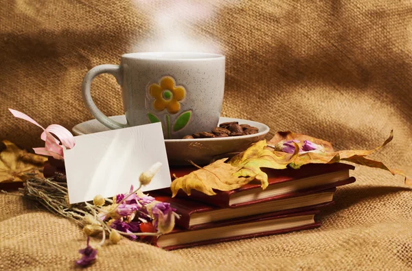 За чашечкой кофе, лежа ot книги с кленовыми листьями — стоковое фото