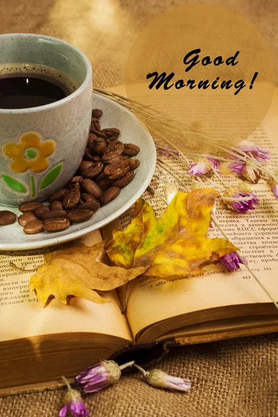 За чашечкой кофе, лежа ot открыл книгу с кленовыми листьями — стоковое фото
