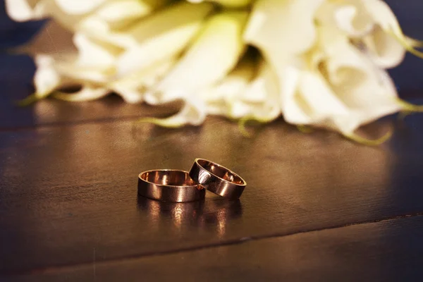 Обручальные кольца и букет из белых лилий — стоковое фото