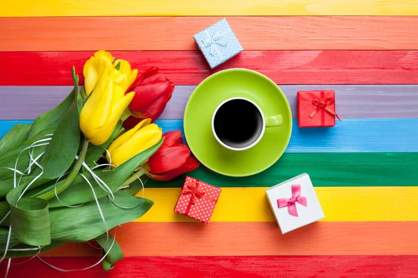 Чашка кофе с тюльпанами и подарки — стоковое фото