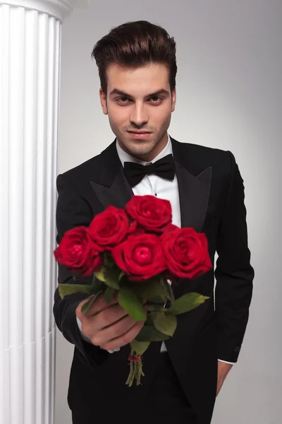 Бизнесмен, дающий Вам букет красных роз — стоковое фото