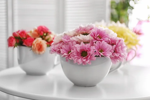 Букеты цветов в чашке на столе — стоковое фото