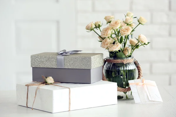 Красивый подарок коробки с букетом цветов на столе перед кирпичной стены, крупным планом Стоковое Изображение