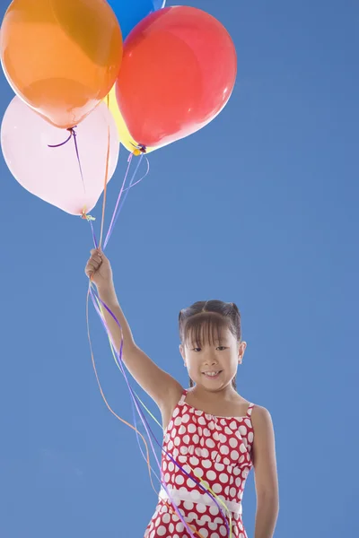Азиатская девочка держит букет из воздушных шаров — стоковое фото