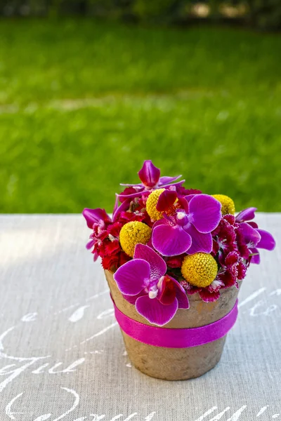 Цветочная композиция с фиолетовые орхидеи и желтый craspedias — стоковое фото
