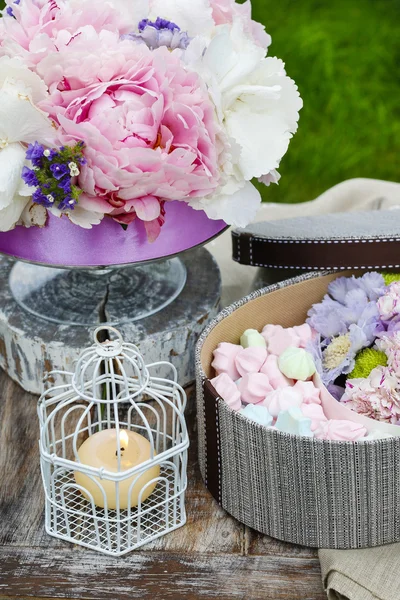 Таблица саду партии: коробка конфет и букет цветов — стоковое фото