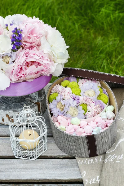 Таблица саду партии: коробка конфет и букет цветов — стоковое фото