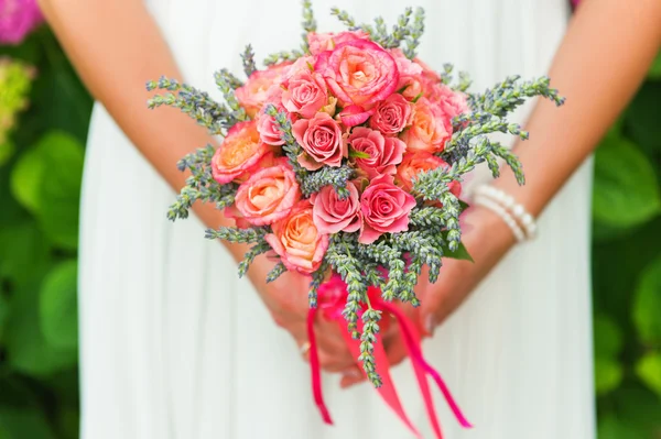 Нежный букет из коралловых роз и зеленой лаванды в руках невесты — стоковое фото