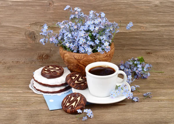 Свежий ароматный кофе с печеньем и букет незабудок поле на фоне деревянные — стоковое фото
