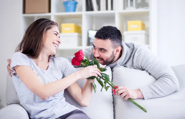 Молодой человек, давая красную розу своей подруге — стоковое фото