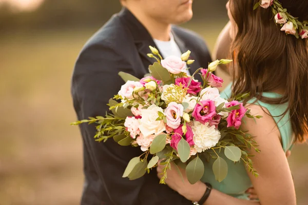 Молодая пара в любви, Открытый на закате - человек дает цветы — стоковое фото