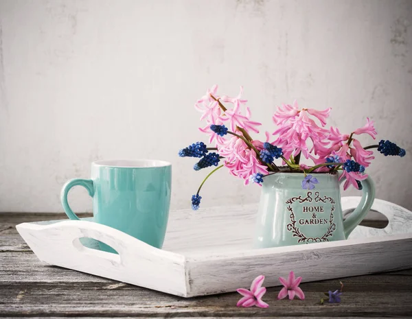 Чашечку кофе и букет цветов на деревянном столе — стоковое фото