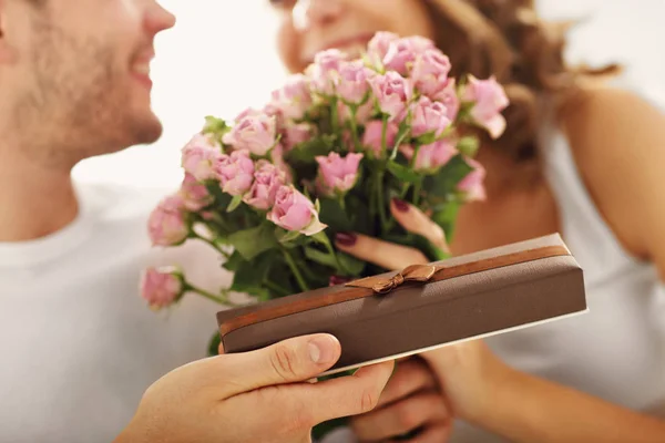 Человек давая цветы и подарить женщине — стоковое фото