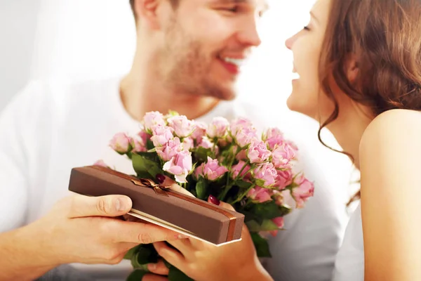 Человек давая цветы и подарить женщине — стоковое фото