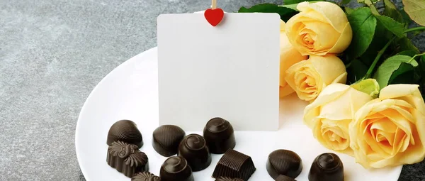Букет красивых роз, конфет и карточку для текста — стоковое фото