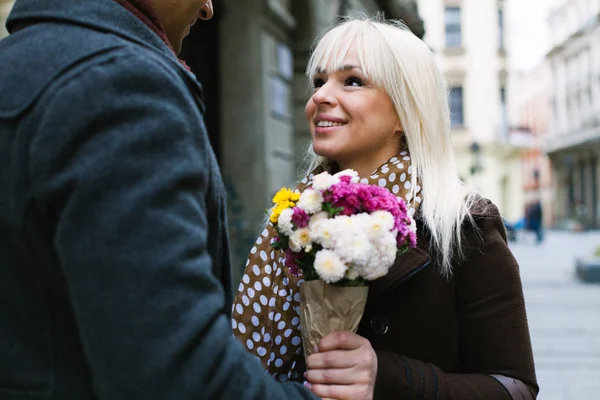 Мужчина дарит цветы своей красивой подругой на свидание — стоковое фото