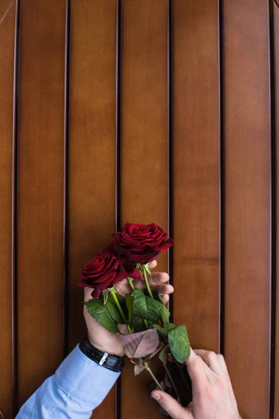 Обрезанное Изображение Мужчина Держит Букет Красных Роз Таблице Стоковое Фото