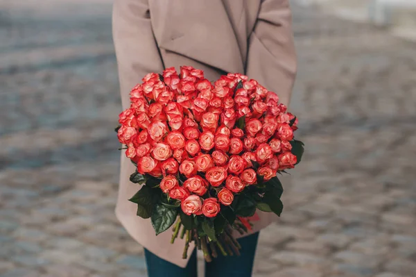 Девушка получила подарок огромный букет из ярких коралловых роз — стоковое фото