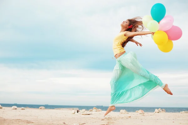 Счастливая девушка с кучей красочных воздушных шаров — стоковое фото