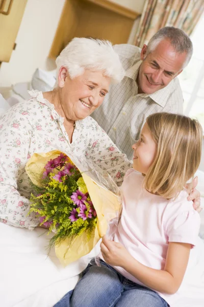 Внучка, дающая цветы ее бабушке в больнице Лицензионные Стоковые Изображения
