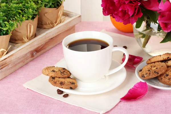 Чашка кофе, печенье, оранжевый и цветы на столике в кафе — стоковое фото