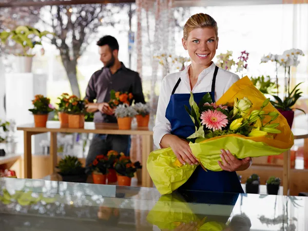 Молодая женщина и клиент в цветочном магазине Лицензионные Стоковые Фото